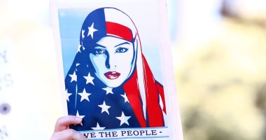 ماهو سر بوستر الفتاة المحجبة بالعلم الأمريكى فى احتجاجات ضد ترامب ؟
