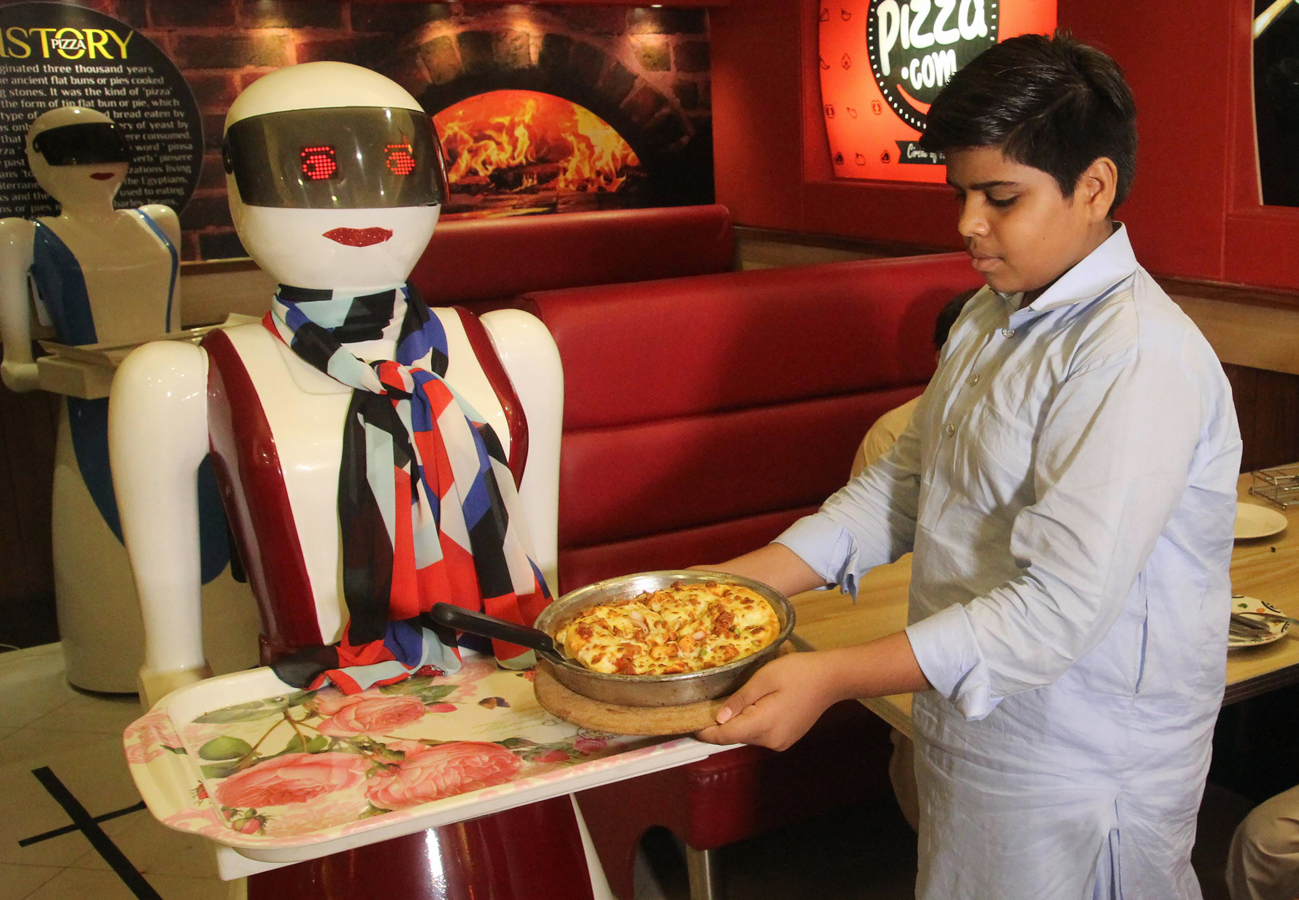 في باكستان.. نادلات آلية لتقديم البيتزا