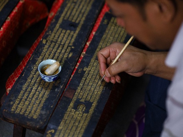 Artists in Nepal repaint Buddhist manuscript with gold